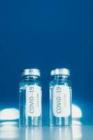 vaccinatie tegen coronavirus covid - 19. flacon Aan een blauw achtergrond detailopname. concept. foto