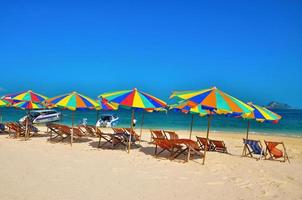 phuket, thailand, 2020 - stoelen en kleurrijke parasols op een strand