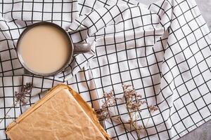 leven vertragen naar beneden concept. kop van koffie en oud boek Aan verfrommeld kleding top visie foto