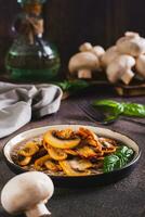 smakelijk gebakken champignons en basilicum bladeren Aan een bord Aan de tafel verticaal visie foto