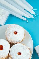 symbolen van Joods religieus vakantie Chanoeka. traditioneel toetje donuts sufganiyot Aan blauw achtergrond. foto