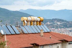 vaten van water verwarmde door zonne- panelen geïnstalleerd Aan dak van huis. concept van besparing elektriciteit. foto