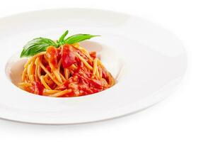 spaghetti met tomaat saus en kers tomaten met basilicum foto