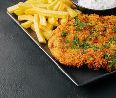 gebakken worstje schnitzel van kalfsvlees bovenzijde met Frans Patat foto