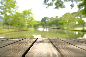 leeg houten tafel met wazig beeld van abstract circulaire groen bokeh van natuur stijl achtergrond. foto