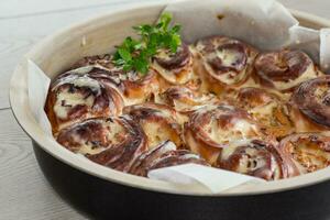 bereid gebakken zoet cinnabon met room in een bakken schotel . foto