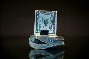 stack van dollar rekeningen verzameld in een elastisch band en een schrijfbehoeften klem foto