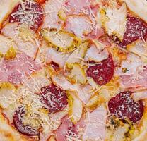 pizza met ham, peperoni en kip foto