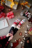 bovenaanzicht van een vrouw in grappige sokken die kerst thuis viert foto