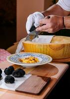 chef rooster truffel krullen Aan pasta met Parmezaanse kaas foto