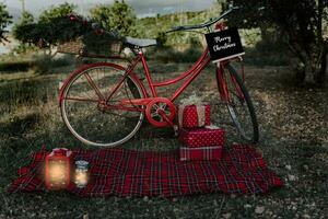 rood fiets met Kerstmis cadeaus en sommige lantaarns buitenshuis foto