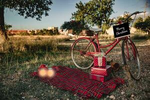 rood fiets met Kerstmis cadeaus en sommige lantaarns buitenshuis foto