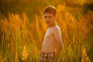 jongen die tussen hoog gras staat foto