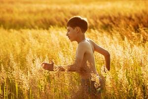 gelukkige jongen die in een veld rent foto