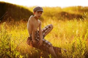 tiener zit op drijfhout foto