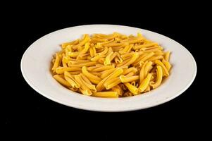 een wit bord van pasta Aan een zwart achtergrond foto