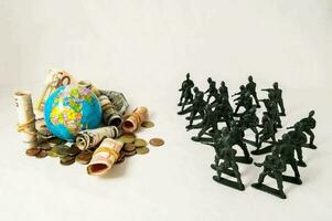 klein beeldjes van soldaten en geld zijn De volgende naar een wereldbol foto