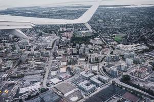 luchtfoto van vliegtuigvleugel op verkeer in drukke stad foto