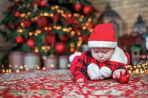 weinig zes maand oud baby gekleed net zo de kerstman claus. achtergrond voor Kerstmis kaart. de kind looks naar beneden Bij de plaats voor inscriptie. foto