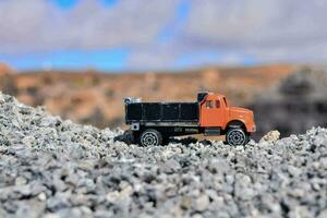 een speelgoed- vrachtauto is zittend Aan top van grind foto