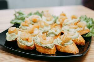 bruschetta met gebakken garnalen en pesto saus Bij een Koken klas. eigengemaakt voedsel, Koken Bij huis. foto