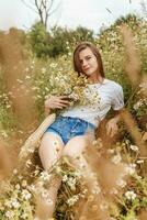 mooi jong vrouw in natuur met een boeket van madeliefjes. veld- madeliefjes, veld- van bloemen. foto