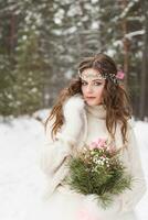 mooi bruid in een wit jurk met een boeket in een met sneeuw bedekt winter Woud. portret van de bruid in natuur foto