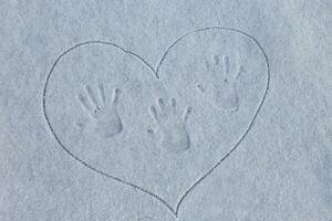 vingerafdruk Aan de sneeuw. drie sporen van handen Aan de sneeuw in geschilderd hart. liefde in de winter. mama, vader en baby. foto