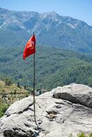 de Turks vlag is vliegend tegen de backdrop van mooi bergen foto