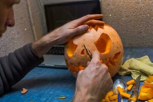 familie pret werkzaamheid. gearriveerd pompoenen in jack-o-lanterns voor halloween. snijwerk groot oranje pompoenen voor halloween in laat herfst. foto