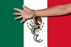 handboeien met de hand op de vlag van mexico foto