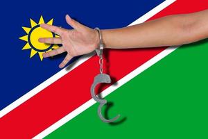 handboeien met hand op de vlag van Namibië foto