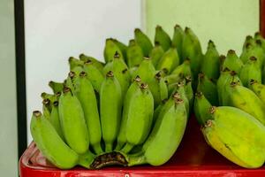 bananen zijn weergegeven Aan een rood tafel foto