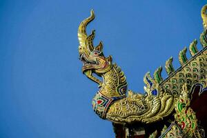 gouden draak Aan de dak van een tempel foto