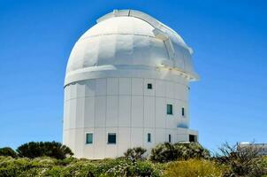 de groot wit telescoop zit Aan top van een heuvel foto