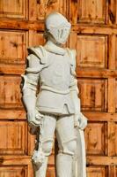 een standbeeld van een ridder in voorkant van een houten deur foto