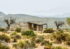 een oud houten huis in de midden- van de woestijn foto
