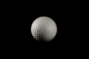 een golf bal Aan een zwart achtergrond foto