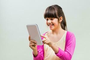 weinig meisje gebruik makend van digitaal tablet foto