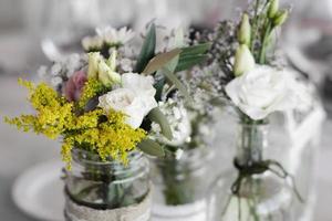 bloemenarrangement en decoratie rustiek interieur in trouwtafel foto