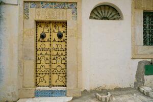 beeld van oud deur in tunesië. Arabisch stijl architectuur. foto