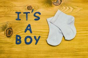 tekst zijn een jongen met weinig baby sokken Aan houten tafel foto