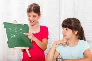 schattig weinig meisjes zijn helpen elk andere met huiswerk foto