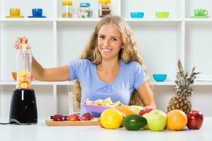 mooi meisje geniet maken smoothie Bij haar huis foto