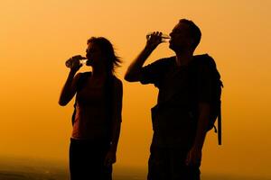 Mens en vrouw wandelaar drinken water foto