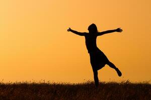 silhouet van gelukkig vrouw jumping in de natuur foto