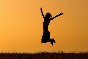 silhouet van gelukkig vrouw jumping in de natuur foto