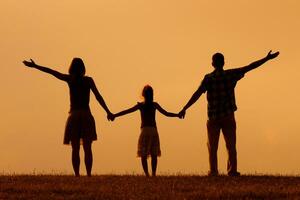 ouders genieten aan het kijken zonsondergang met hun dochter foto