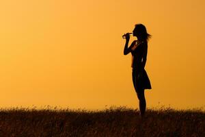 silhouet van een vrouw drinken water buitenshuis foto