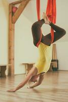 vrouw aan het doen antenne yoga in de geschiktheid studio foto